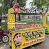 Hình ảnh xe bán trà sữa lưu động màu vàng, gắn chữ mica nổi phát sáng nổi bật thu hút khách